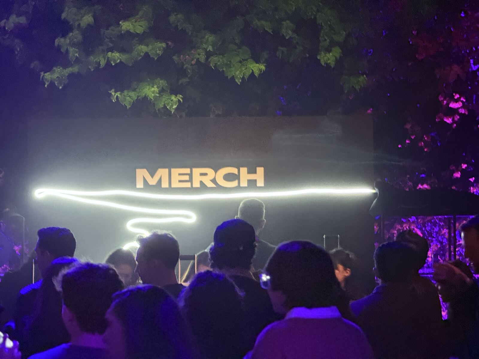 Event floor view showing the printing booth and merchandise displays with a crowd of guests